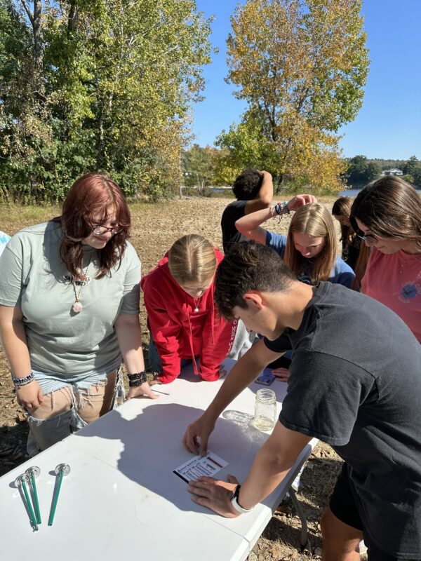 young people outside doing water monitoring research