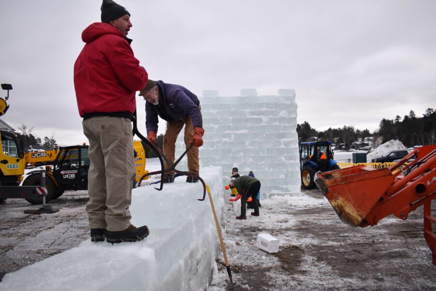 Members of the International Palace Workers Local 101 use ice tongs to position the next block of ice while slushers work in the background filling the joints with mortar — a mix of snow and water mixed to the consistency of mashed potatoes.
