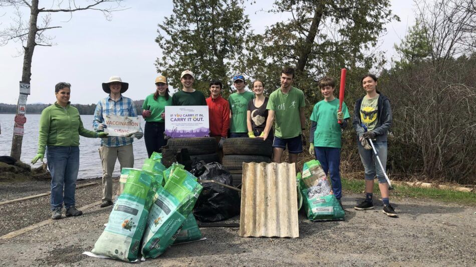 A group of young people celebrate Earth Day at a lake
