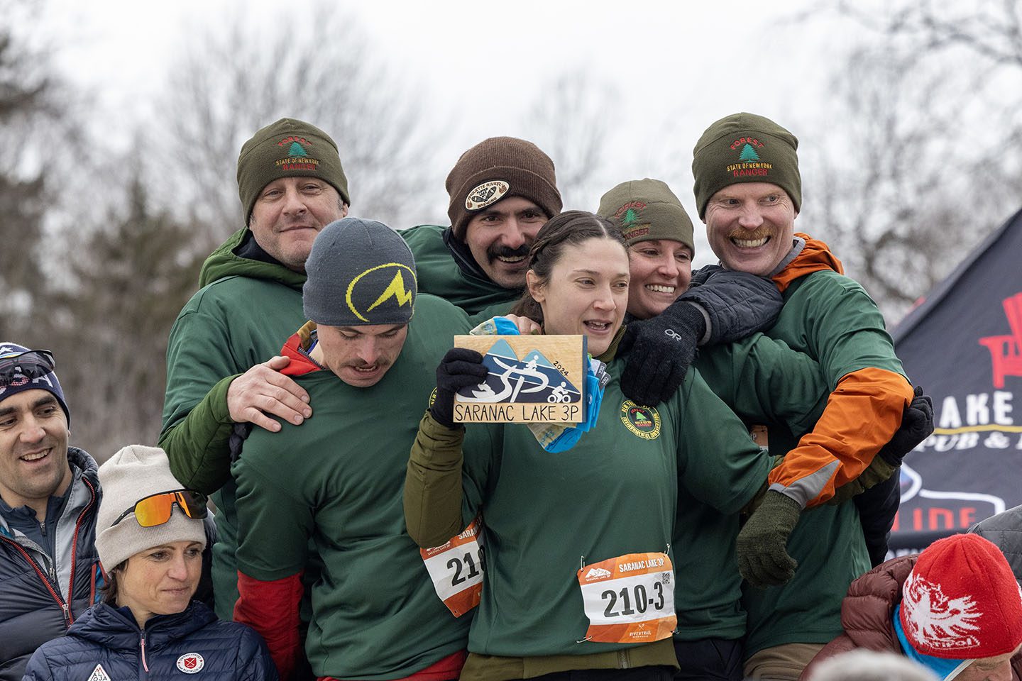 Forest rangers, shown here crowding onto the podium, took first place in the team division of the Saranac Lake 3P race on Saturday in Saranac Lake. 