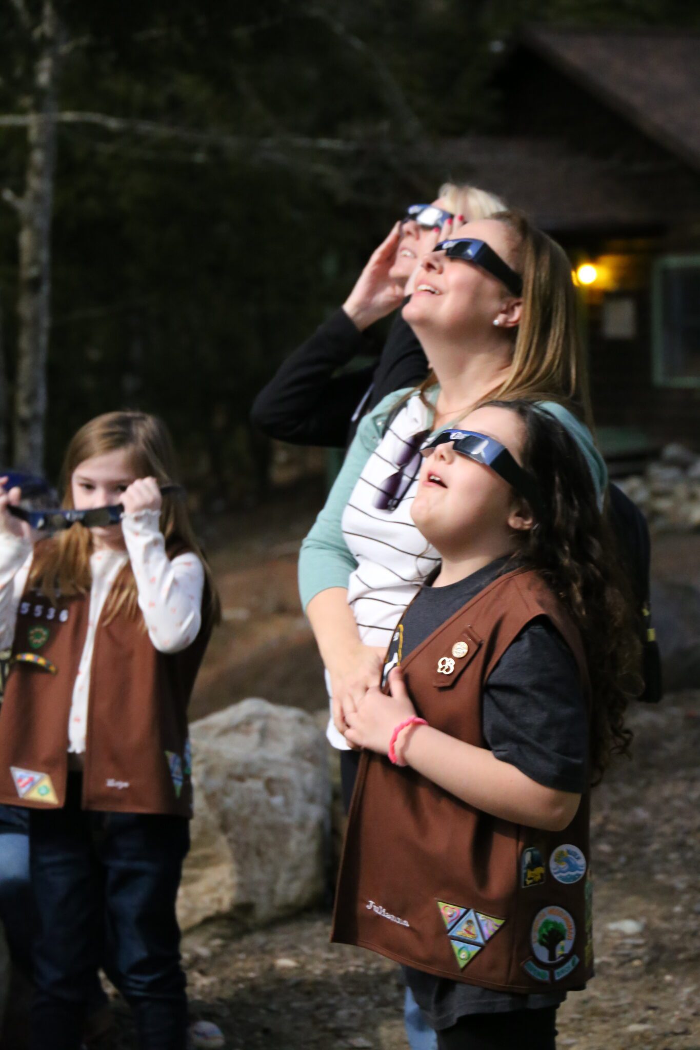 Eight-year-old Julianna Notaro, a Brownie from Wynantskill, watches the solar eclipse with her mother on Monday at Hidden Lake Girl Scout Camp in Lake Luzerne.