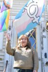 LGBTQ activist Kelly Metzgar stands with her Pride flags.