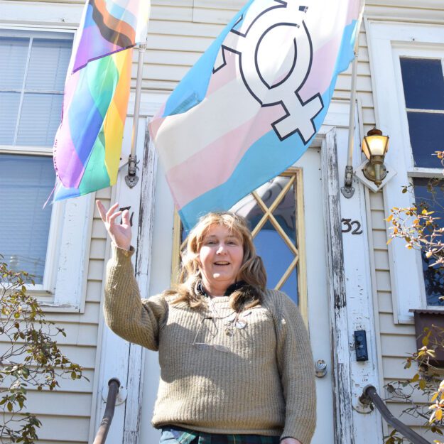 LGBTQ activist Kelly Metzgar stands with her Pride flags.