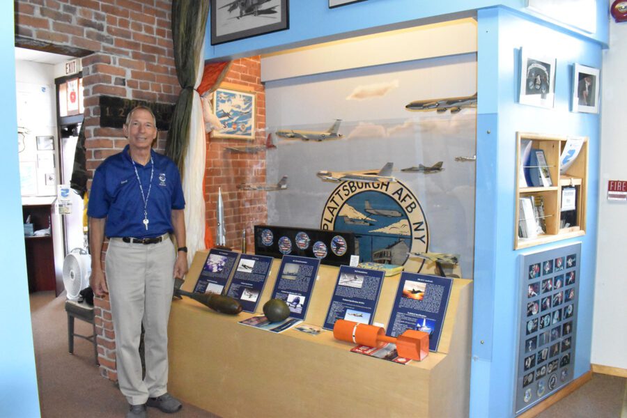 man in front of display at air force museum in plattsburgh