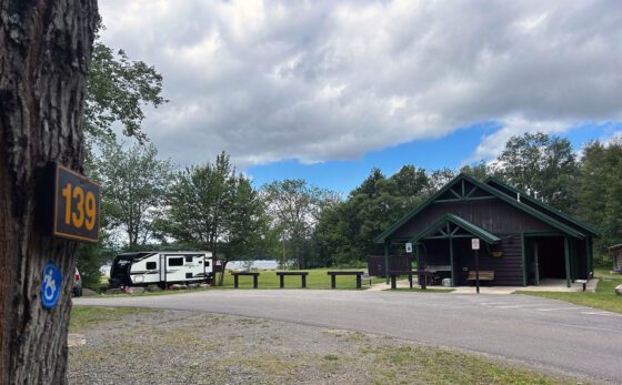 Dark brown and green wheelchair-accessible bathroom building at a campground.