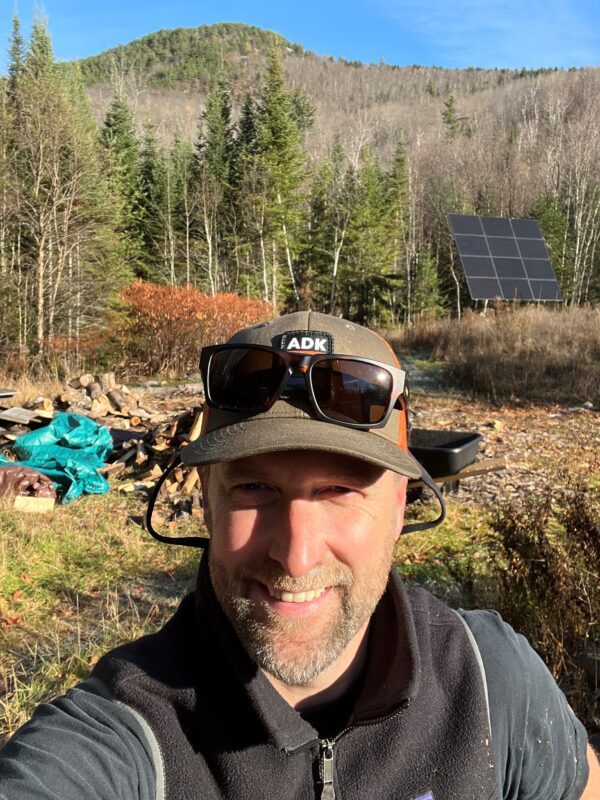 Man stands in front of solar panel