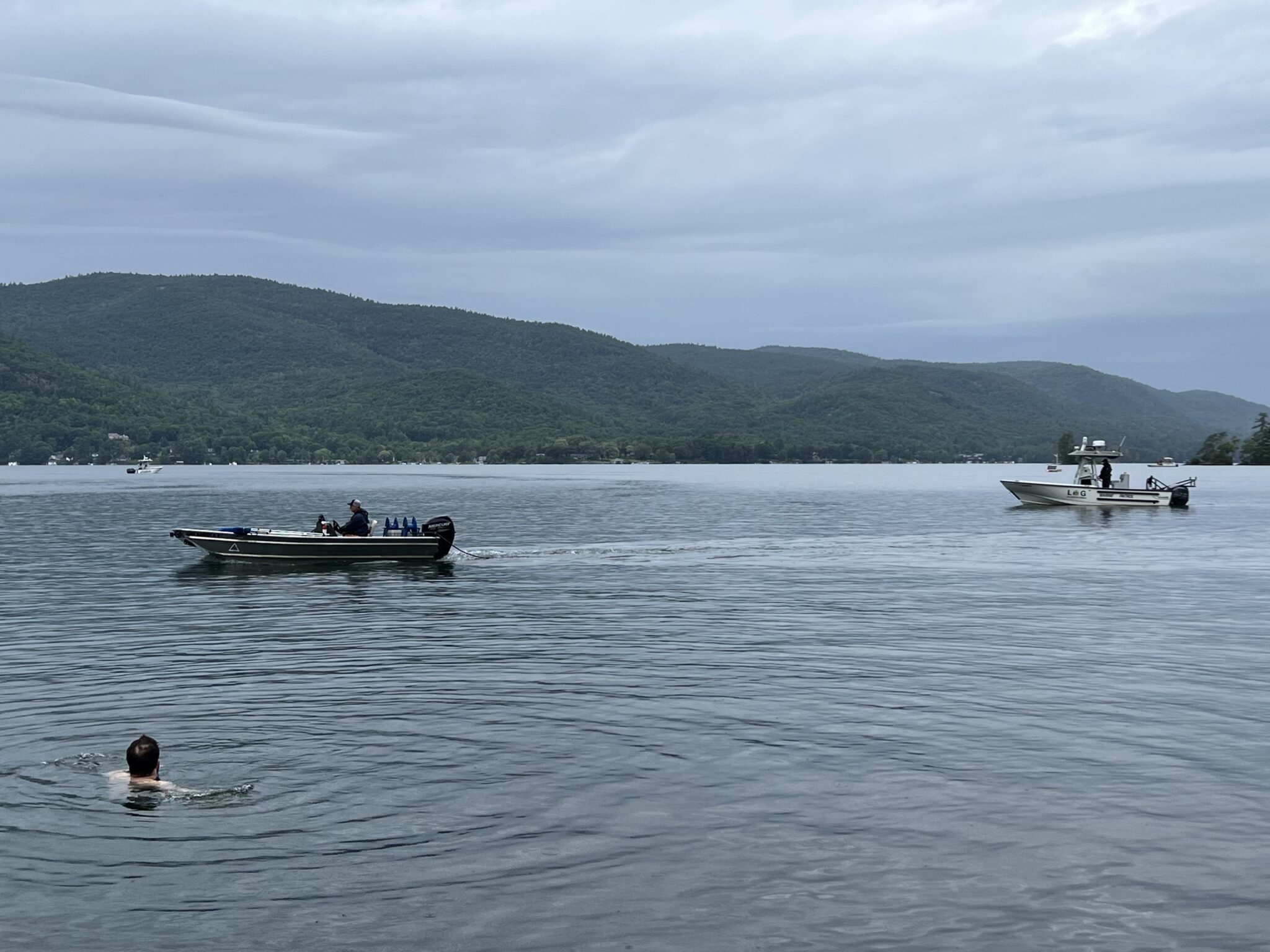 A contractor applies the herbicide ProcellaCOR to Sheep Meadow Bay in Lake George as a swimmer looks on. 