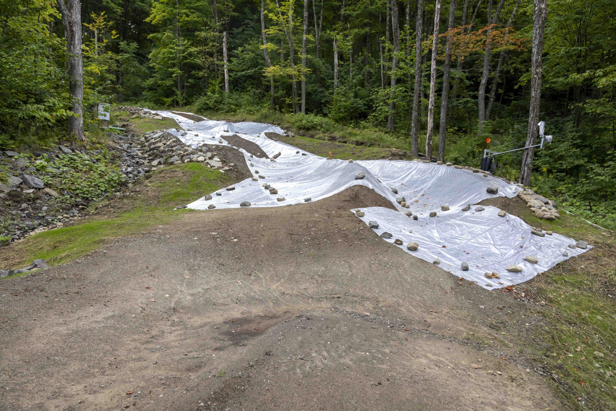 dirt marked with tarps on the future mountain bike race course