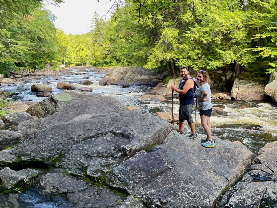 couple walking on rocks in the sacandaga river