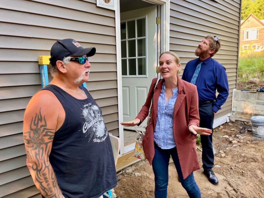 three people outside a house, an adirondack rental rehabbed by the Essex County Land Bank