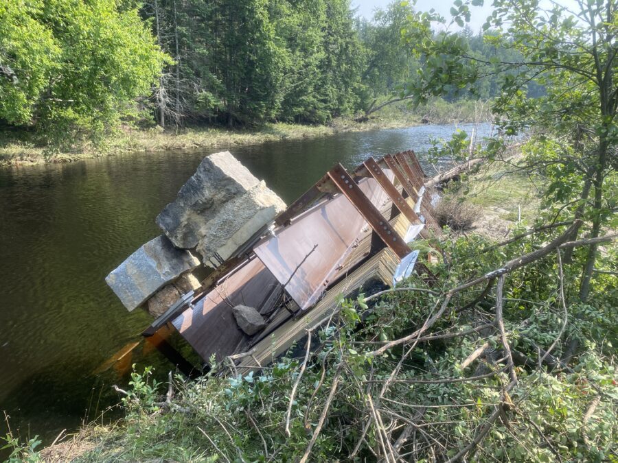 A bridge washed away in a river after a flood in Newcomb