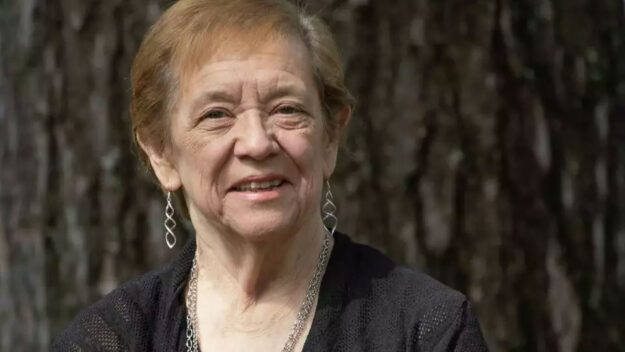 Edinburg town Supervisor Jean Raymond is retiring after more than three decades leading the town. She's wearing black and standing against a tree