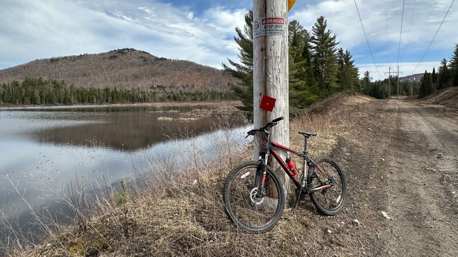 a bike in the foreground with a pond and mountain in the background