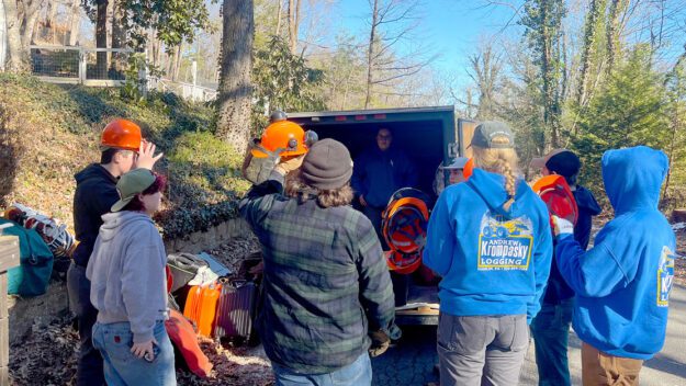 Paul Smith's College students gathered around the trailer distributing Personal Protective Equipment (PPE) before assisting Paul Smith's College alums by clearing downed trees and debris from their property. Lake Lure, NC, January 2025. Photo courtesy Paul Smith's College