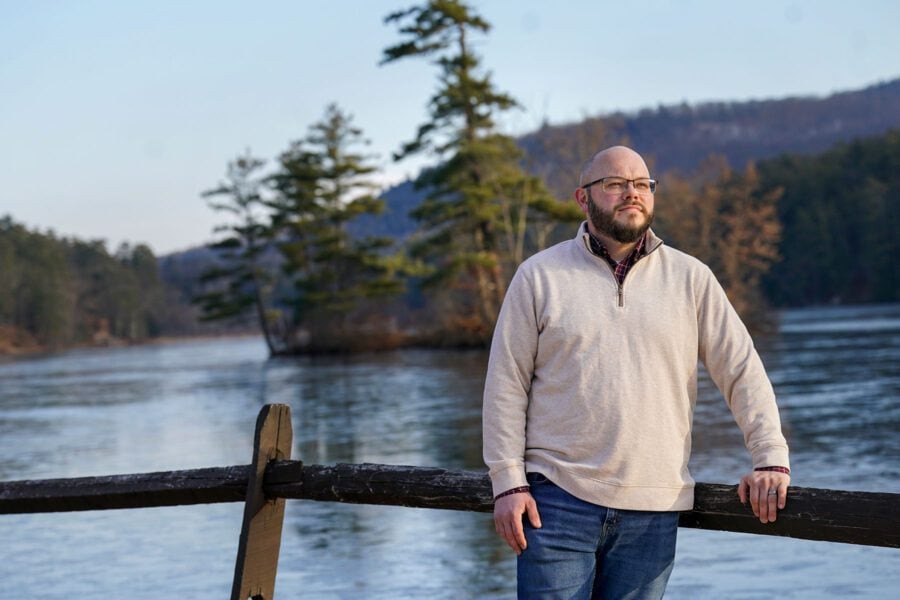 man standing next to a lake in Lake Luzerne