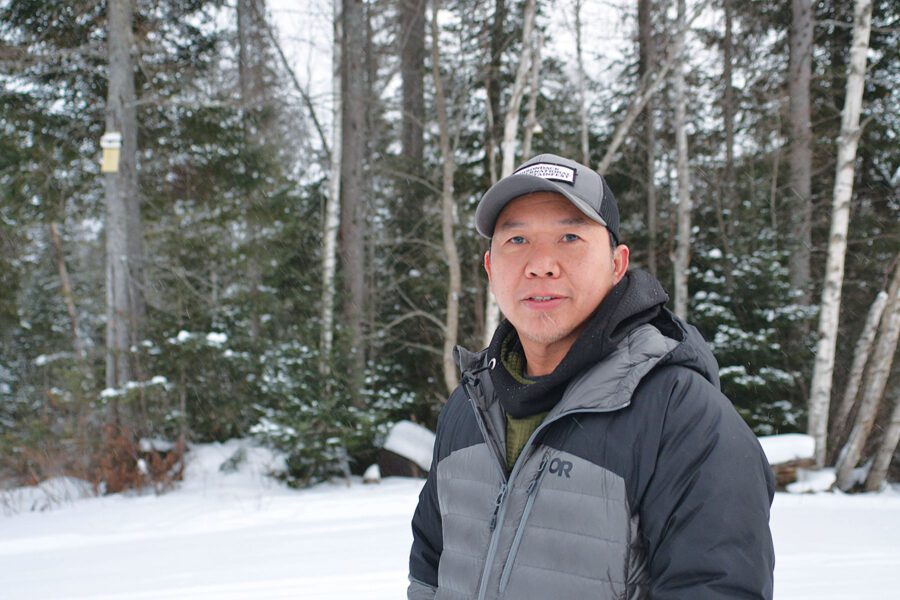 Man in the snowy woods in winter gear, of the adirondack leaders blazing a trail for others