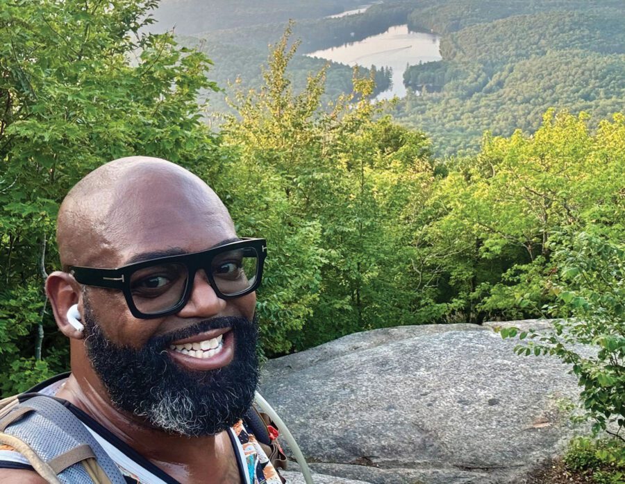 Man in glasses atop a mountain