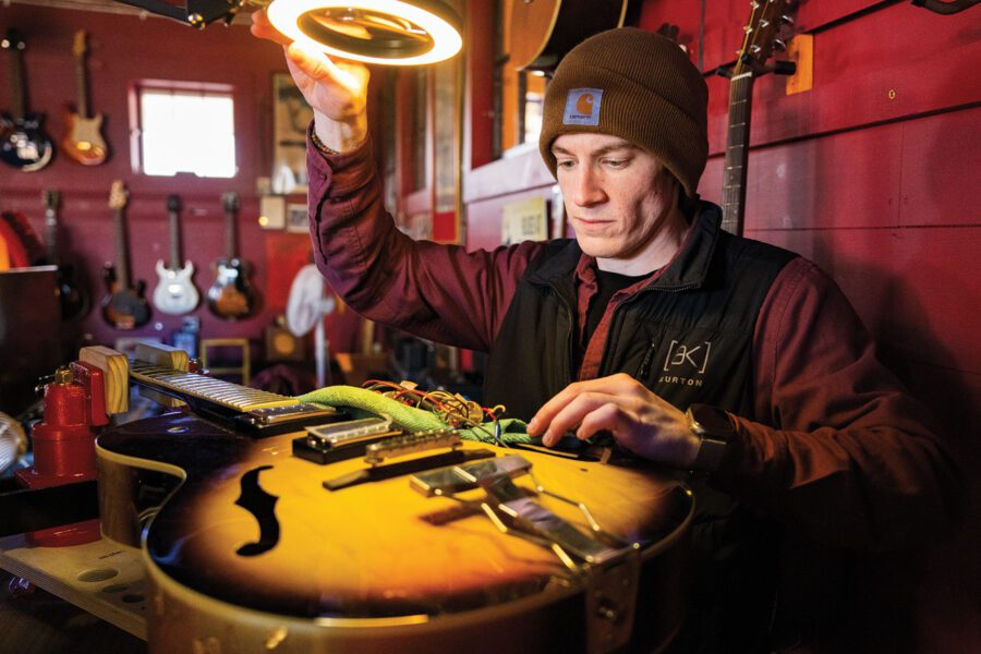 Person repairs the electronics on a guitar