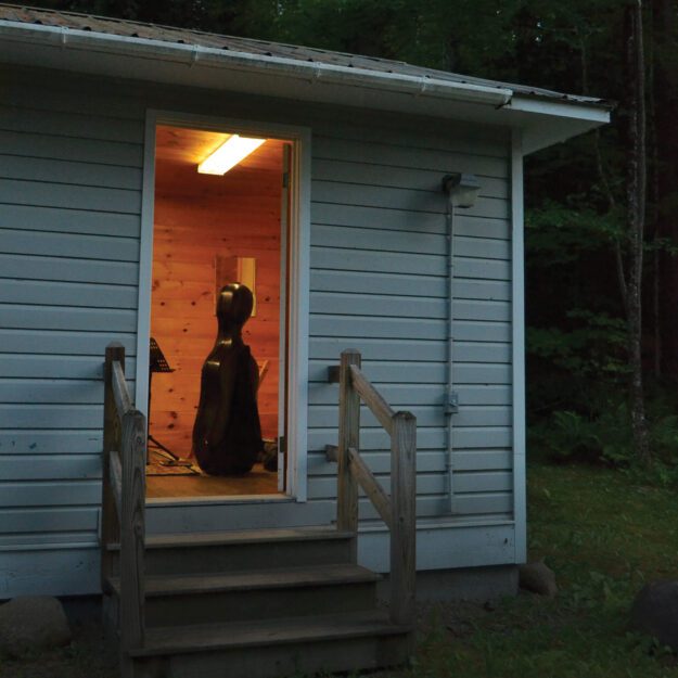 A string instrument sitting inside the open door of a cabin