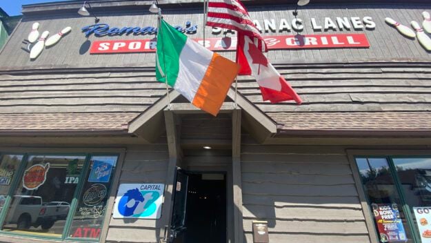 a trio of flags in front of a business: Italian, American and Canadian