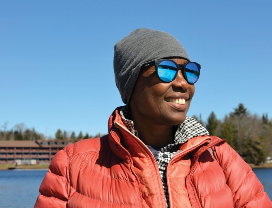 Woman in sunglasses and an orange coat on a lake