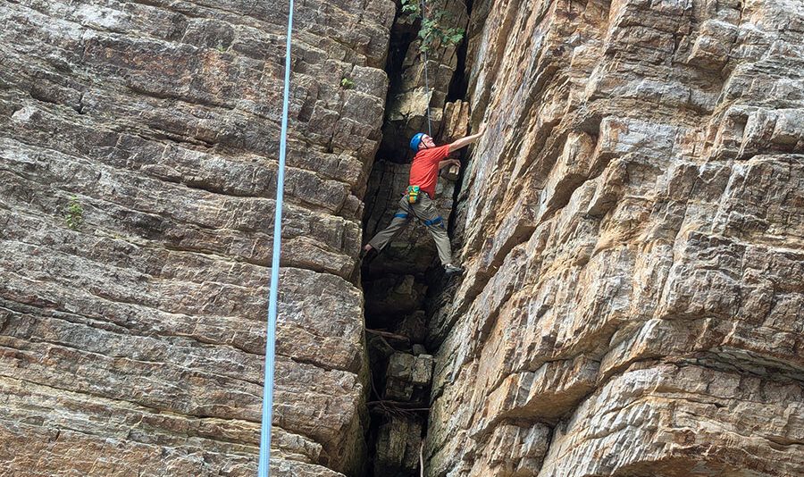 man climbing in narrow rock wall
