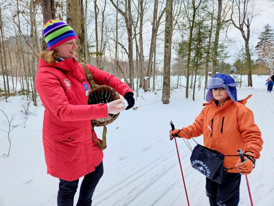 AmeriCorps member Noelle Wobig passes out marshmallows for a S’more-ski event. Children received elements of a s’more from AmeriCorps members at various stations along a ski loop at the James C Frenette Sr. Recreational Trails.  Participants convened at the fire pit to make their s'mores and have hot cocoa.  Photo Courtesy of The Wild Center.


