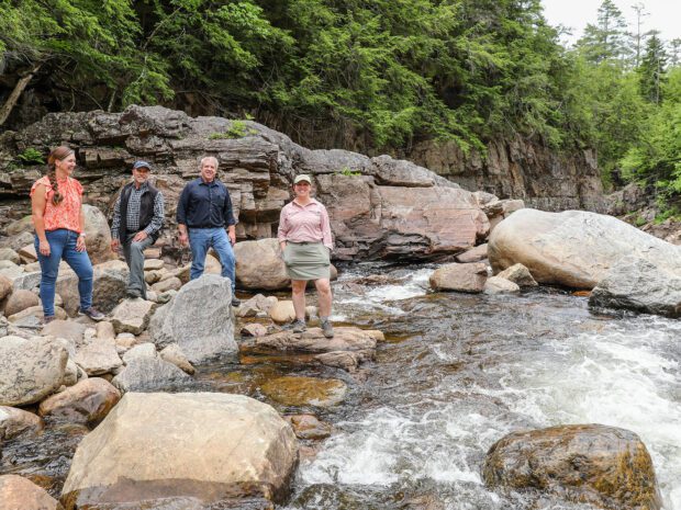 From left, Hamilton County IDA Executive Director Christy Wilt, Hamlets to Huts Executive Director Joe Dadey, local government leader Bill Farber, and ALT's Megan Stevenson at Griffin Gorge on the East Branch of the Sacandaga River in the town of Wells. Erika Bailey, courtesy Adirondack Land Trust