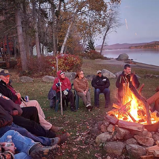 people around a campfire at homeward bound adirondacks retreat center
