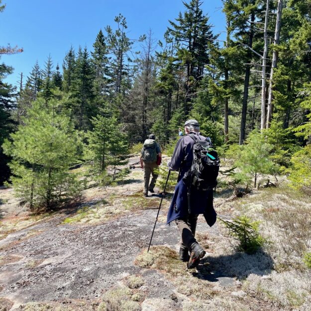 Hikers cross rocks