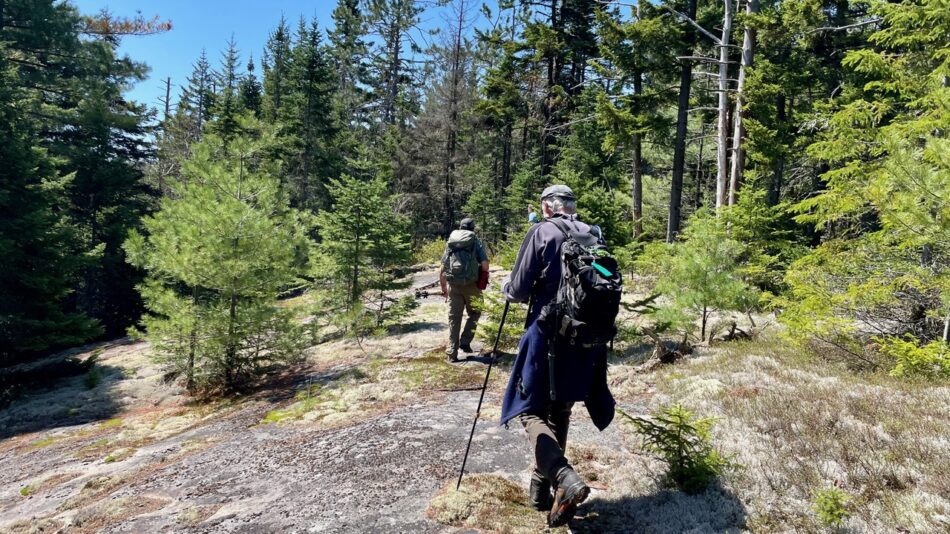 Hikers cross rocks