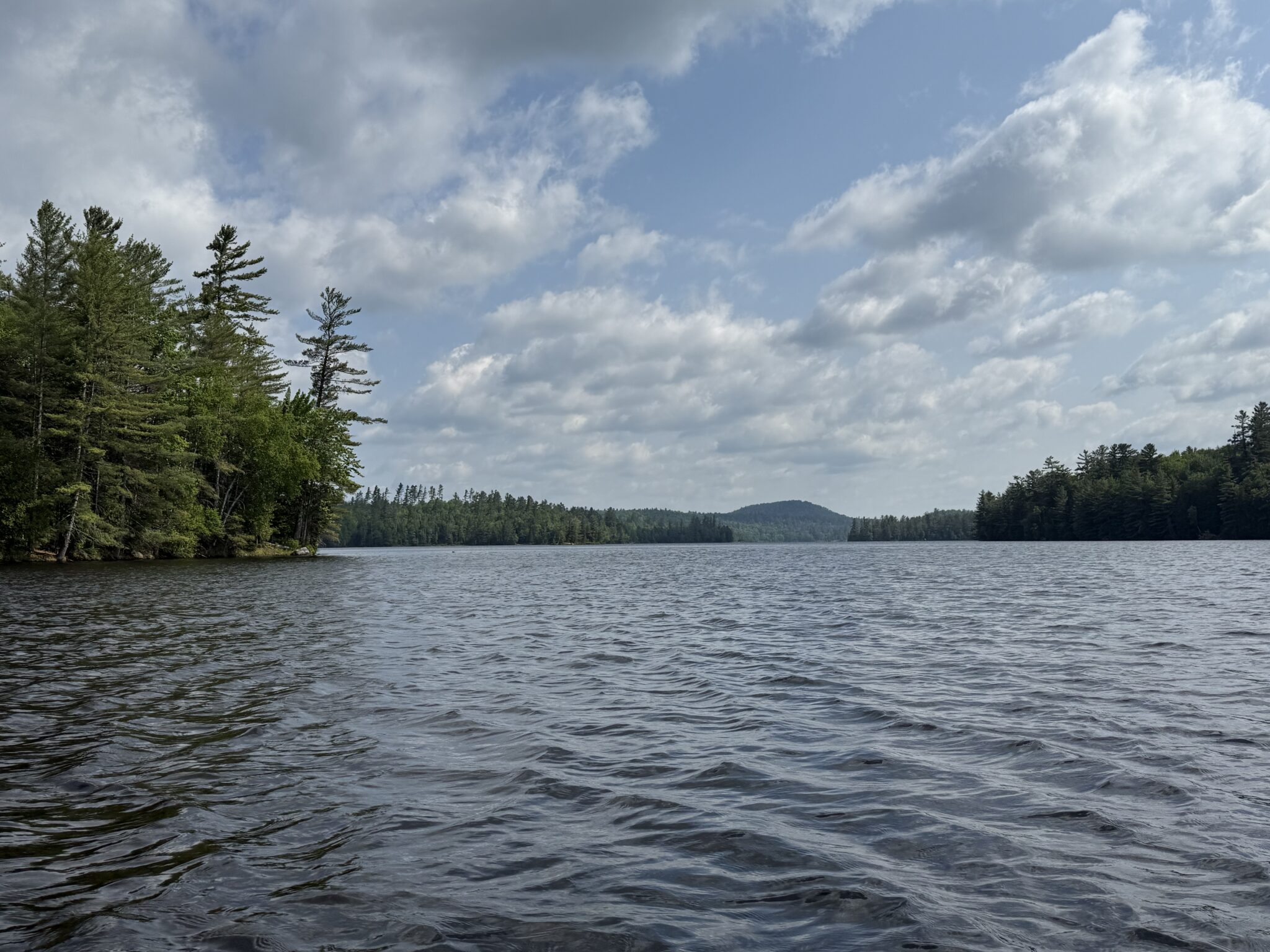 a stretch of rippling water with a mountain in the background