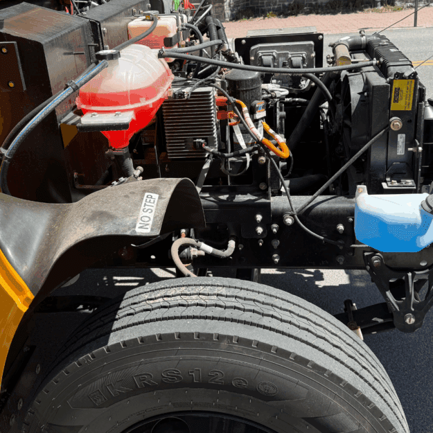 A yellow school bus engine compartment displays the mechanical systems