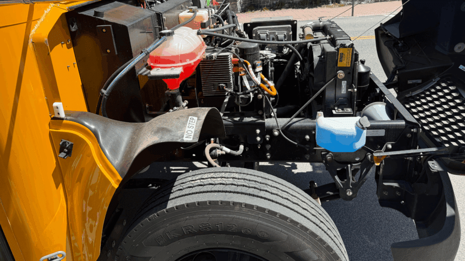 A yellow school bus engine compartment displays the mechanical systems