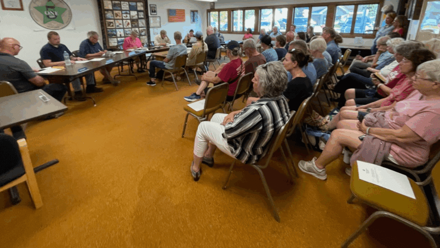 About 30 people attended seated in a room with a yellow carpet facing a table of men in the front for a meeting of the Indian Lake Zoning Board of Appeals out of concern over a proposed home on Blue Mountain Lake.