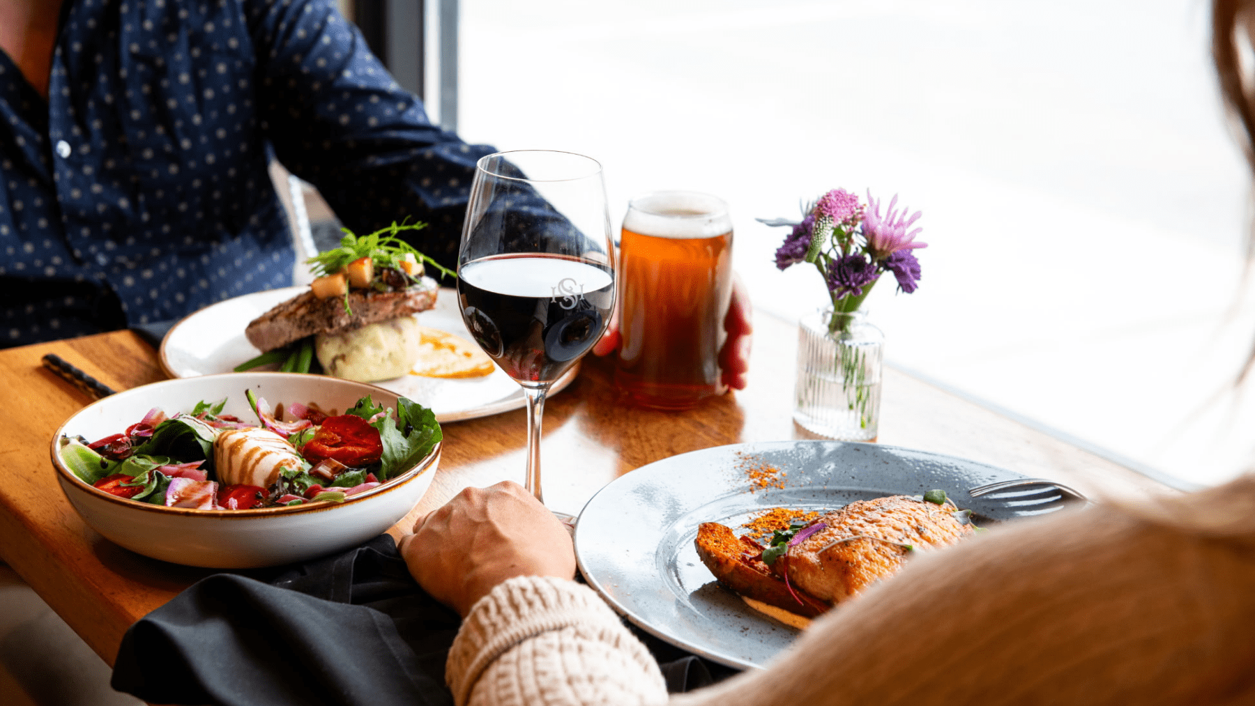 Close up of a two people at a table having a meal at Hotel Saranac Campfire Grill
