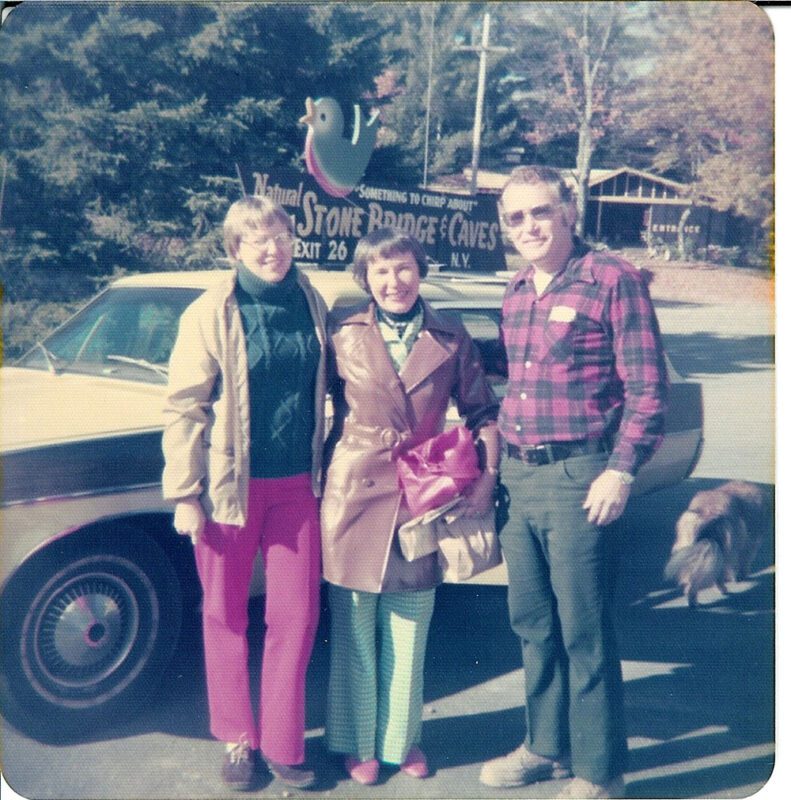 Three people in front of a station wagon