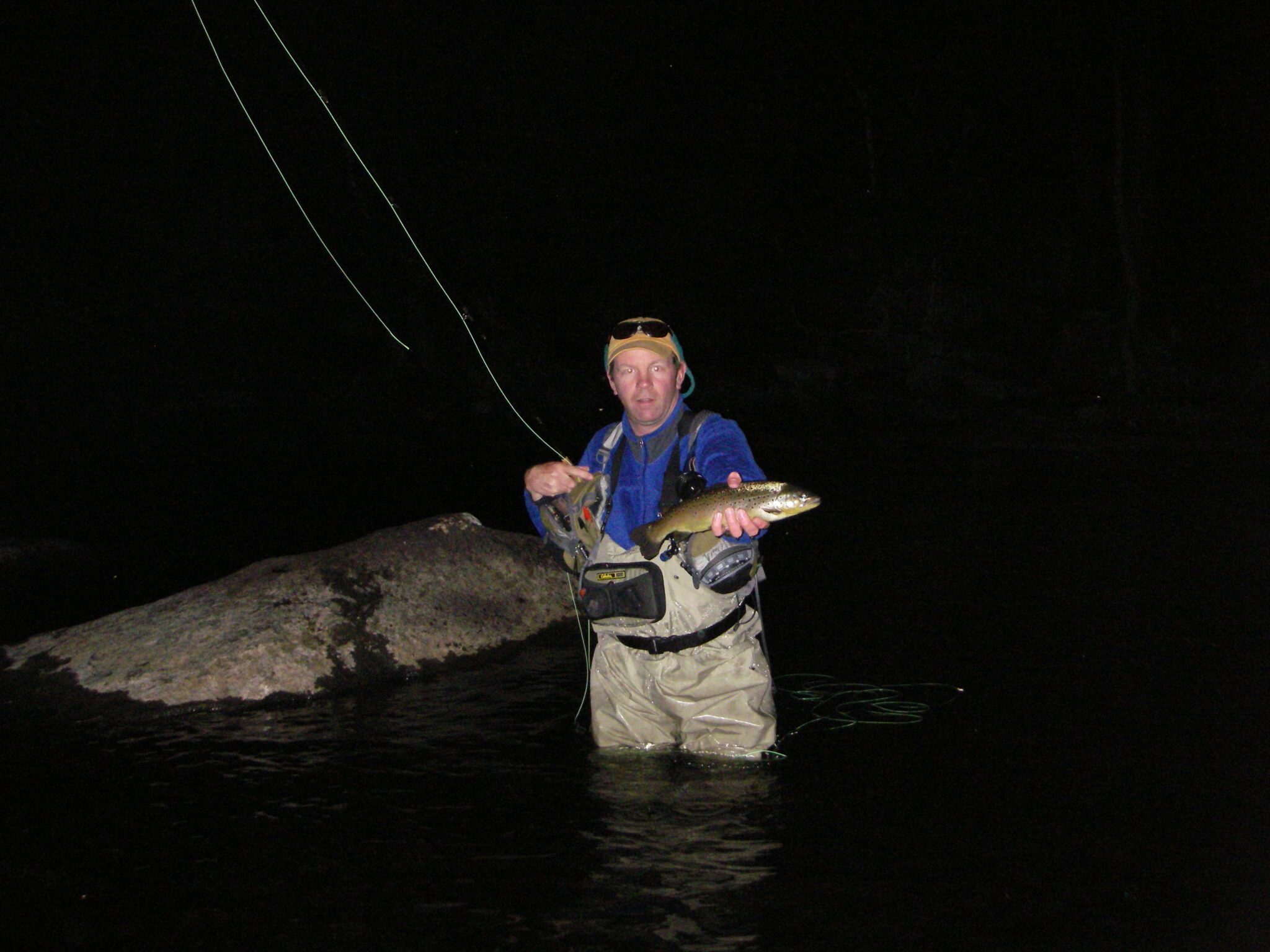 Man Shows off a Brown Trout Caught on the Upper Hudson River caught during a Zebra Caddis Hatch during the night time