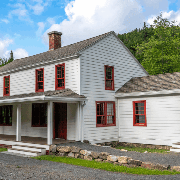 White cottage with red shutters