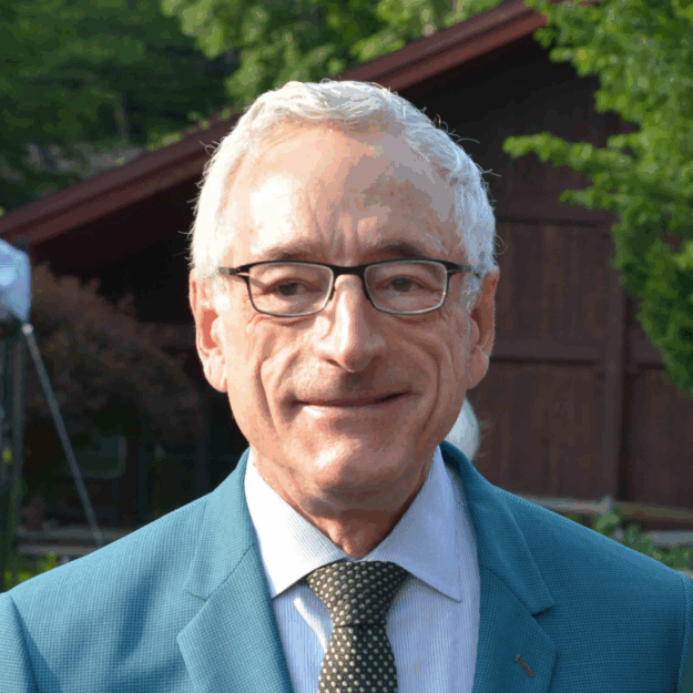 Head shot of man in glasses, blue blazer, white shirt, and tie
