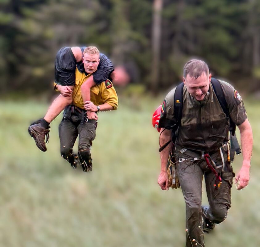 Ranger Lewis carries the patient to the helicopter at Elk Pass.