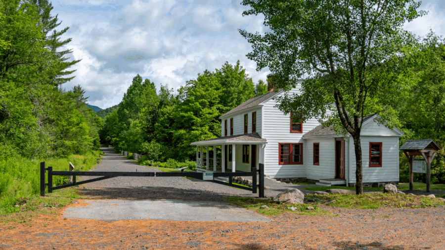 White cottage with red trim and gate 