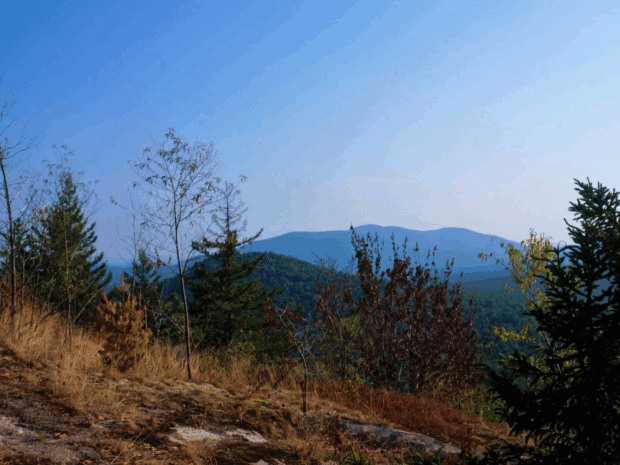 View looking out from mountain to blue peak