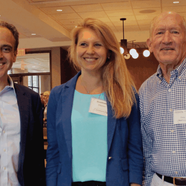 From the left, man with dark suit jacket and button up shirt, woman in light blue shirt and dark blue blazer, older man with button up shirt and belted khakis