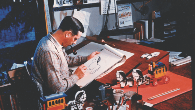 Arto Monaco at his design table where he created thousands of fanciful toys, dolls, miniature figures and whole towns. Courtesy of the Adirondack History Museum.