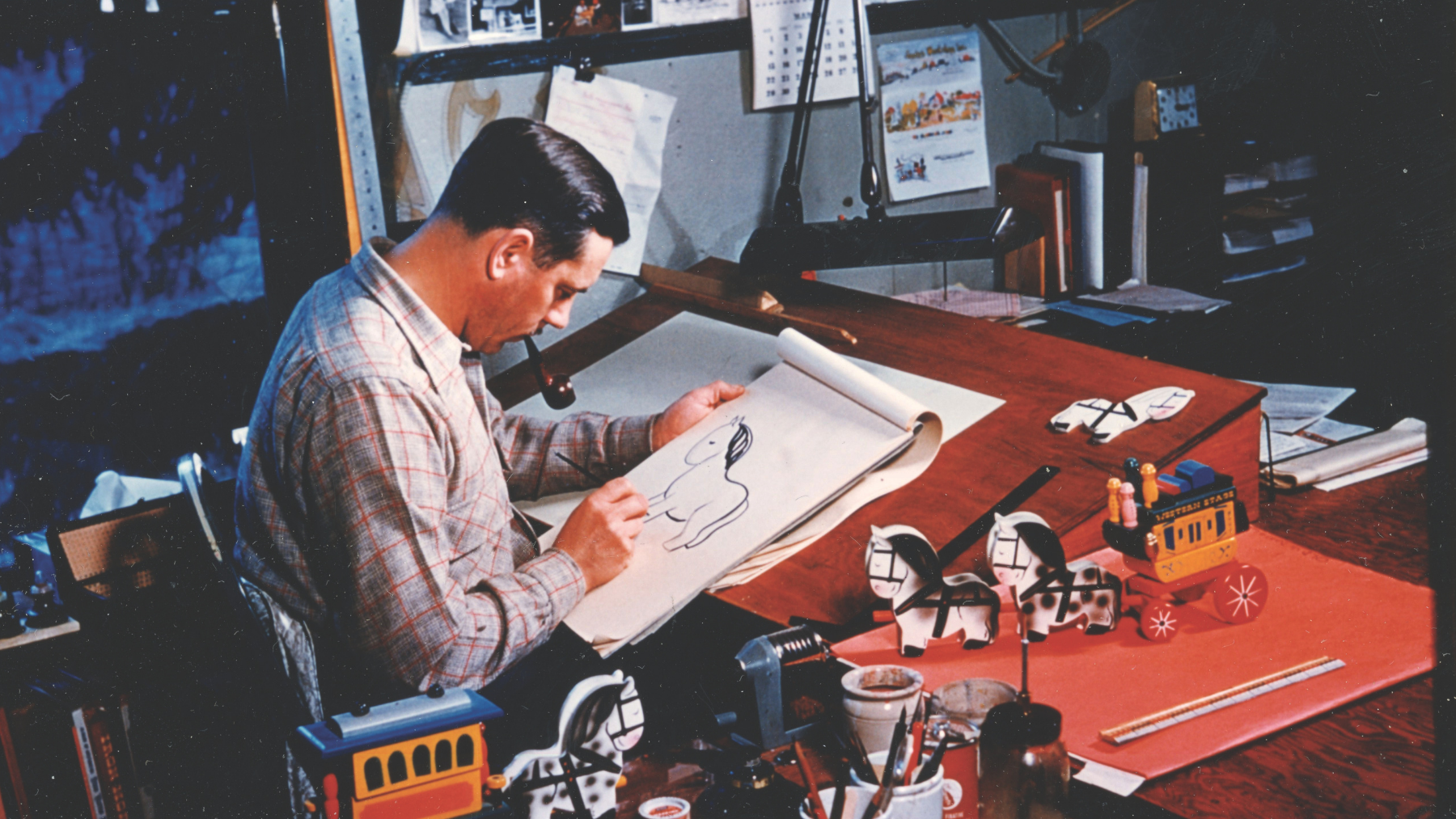 Arto Monaco at his design table where he created thousands of fanciful toys, dolls, miniature figures and whole towns. Courtesy of the Adirondack History Museum.