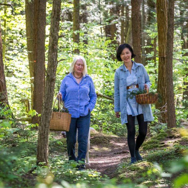 two women of adirondack fragrance farm walking in the woods