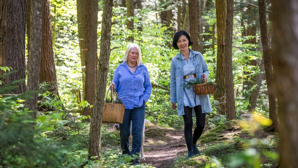 two women of adirondack fragrance farm walking in the woods