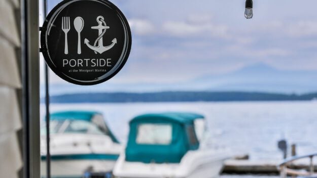 Portside sign overlooking lake with boats in the background