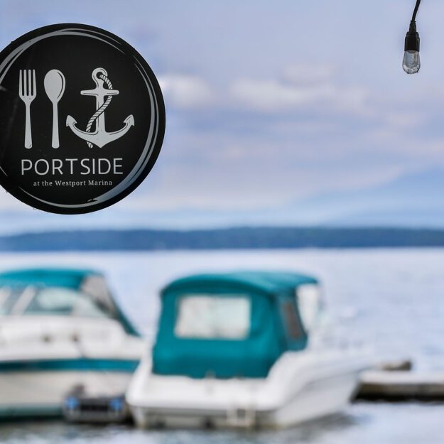 Portside sign overlooking lake with boats in the background
